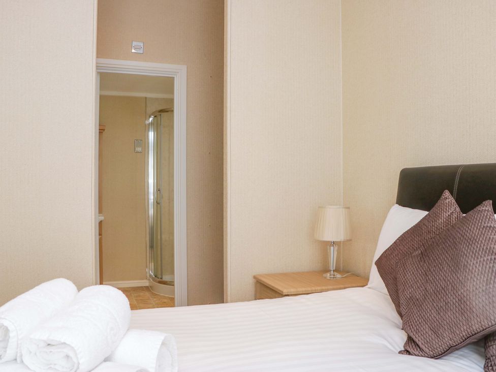 A bedroom with a bed and towels at Wansfell 2 in Limefitt Park near Troutbeck