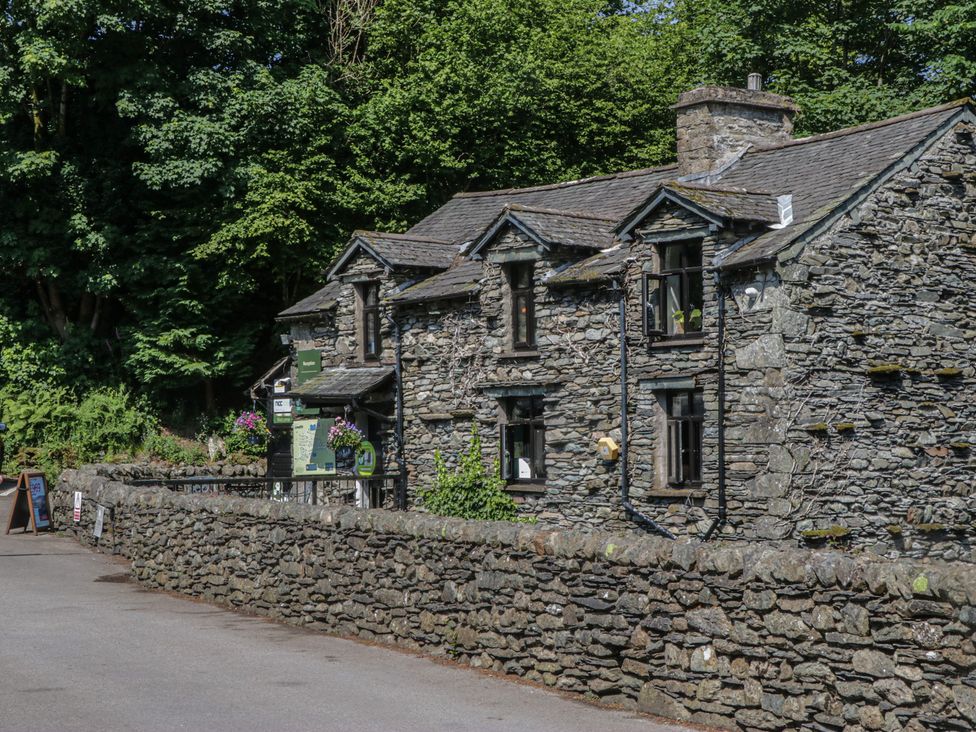A stone building with windows and flower pots at Wally's Folly in Limefitt Park near Troutbeck