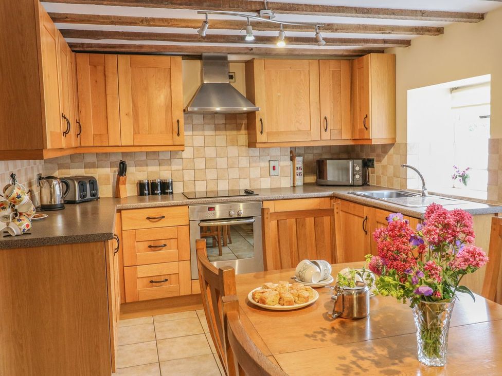 A kitchen with wooden cabinets and appliances at Orchard View in Ashbourne