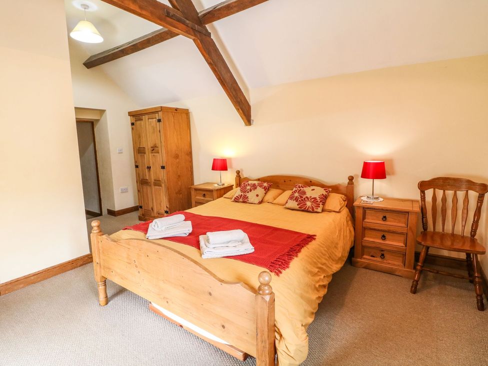 A bedroom with a bed, nightstand, and wardrobe at Orchard View Ashbourne