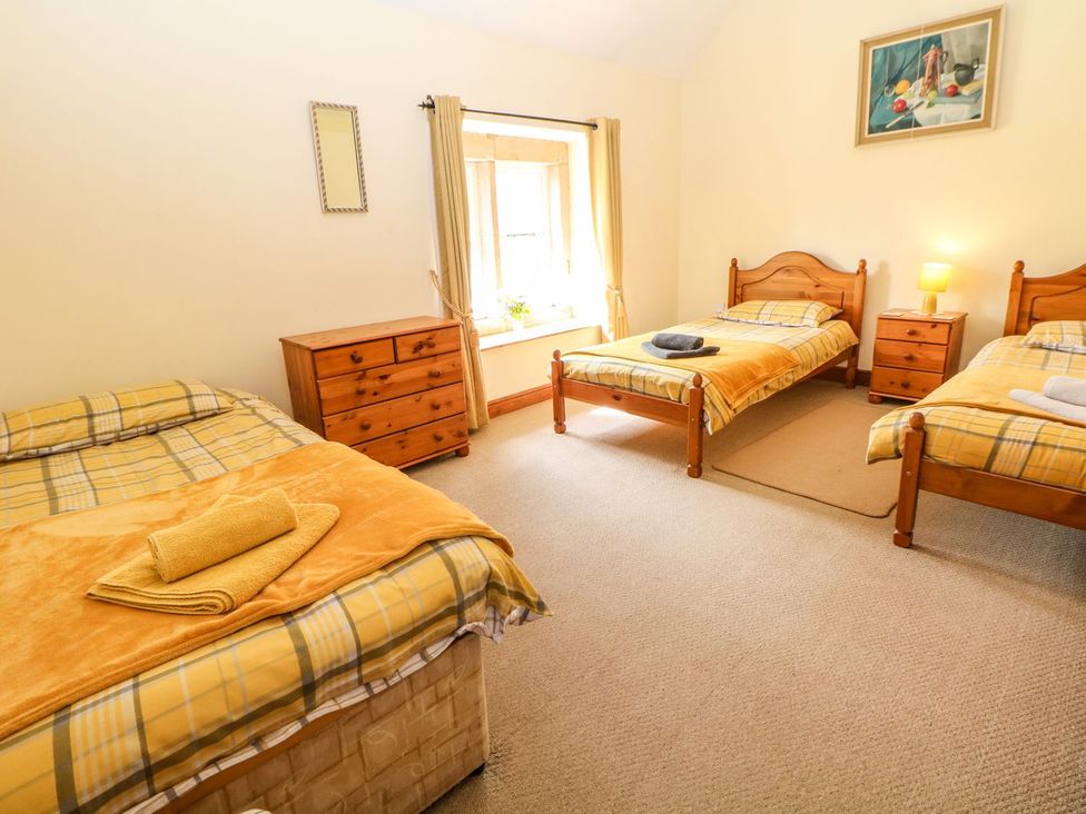A bedroom with three beds and a dresser at Orchard View in Ashbourne