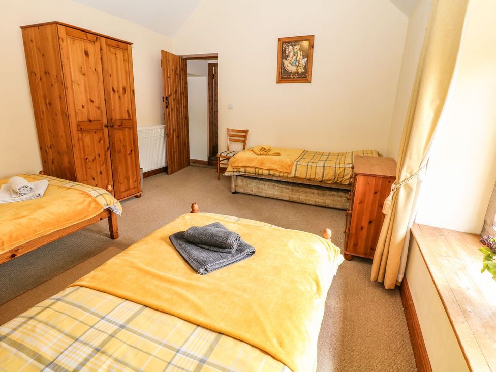 A bedroom with beds and a wardrobe at Orchard View in Ashbourne