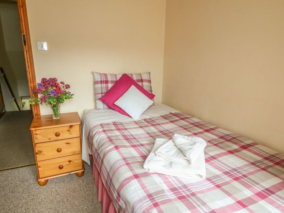 A single bed with pillows and towels at Orchard View in Ashbourne