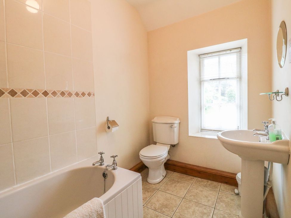 A bathroom with a bathtub, toilet, and sink at Orchard View in Ashbourne