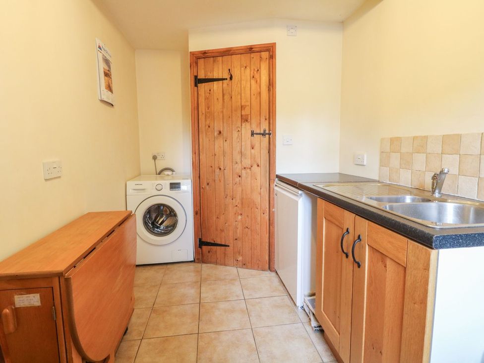 A utility room with a washing machine and sink at Orchard View Ashbourne