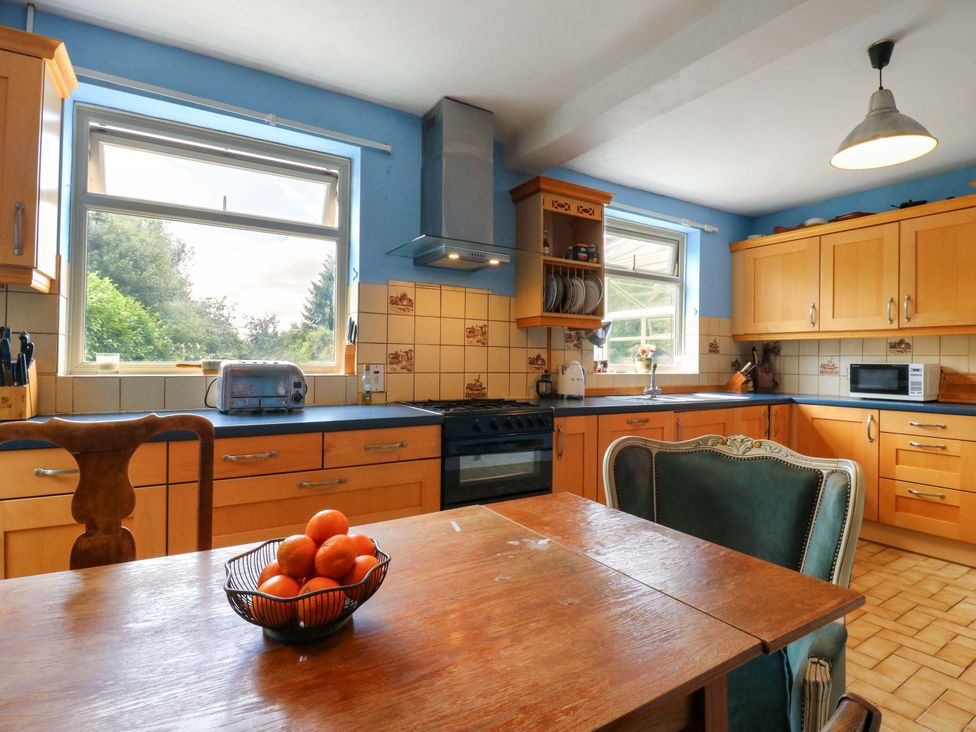 A kitchen with appliances and a dining table at Hillside in High Wycombe