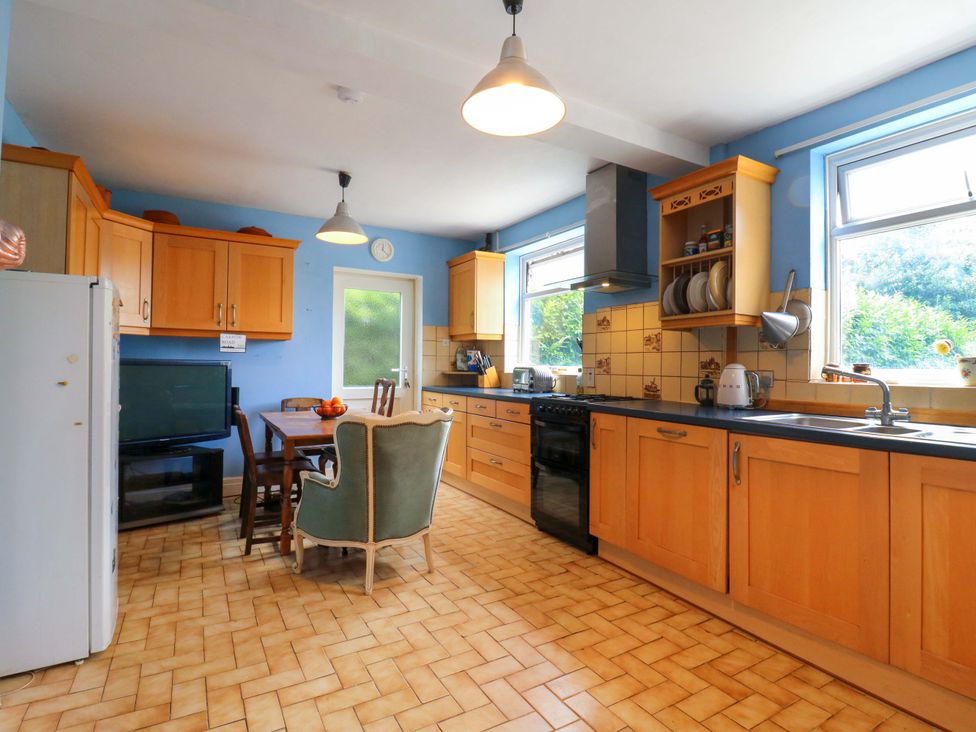 A kitchen with wooden cabinets and a dining area at Hillside in High Wycombe