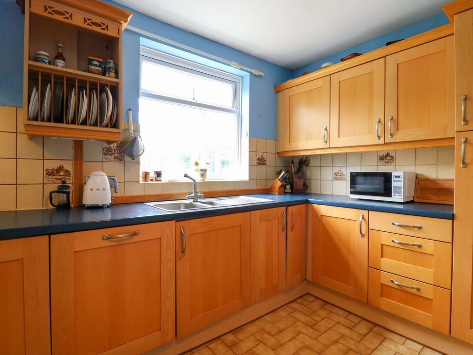 A kitchen with wooden cupboards and a sink at Hillside in High Wycombe