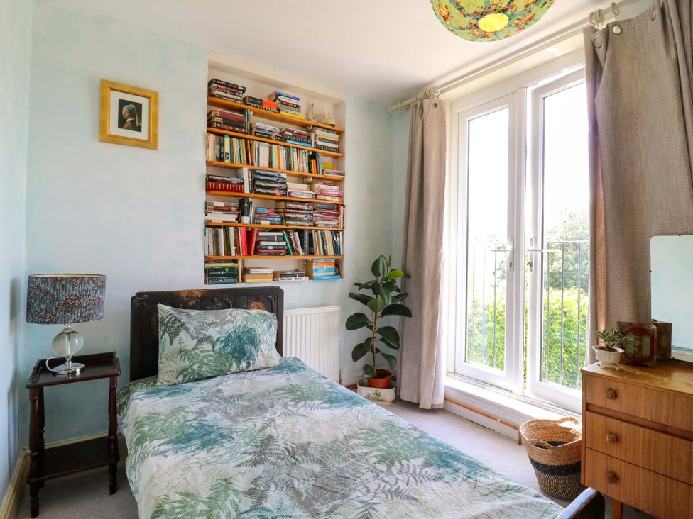 A bedroom with a single bed and bookshelf at Hillside in High Wycombe