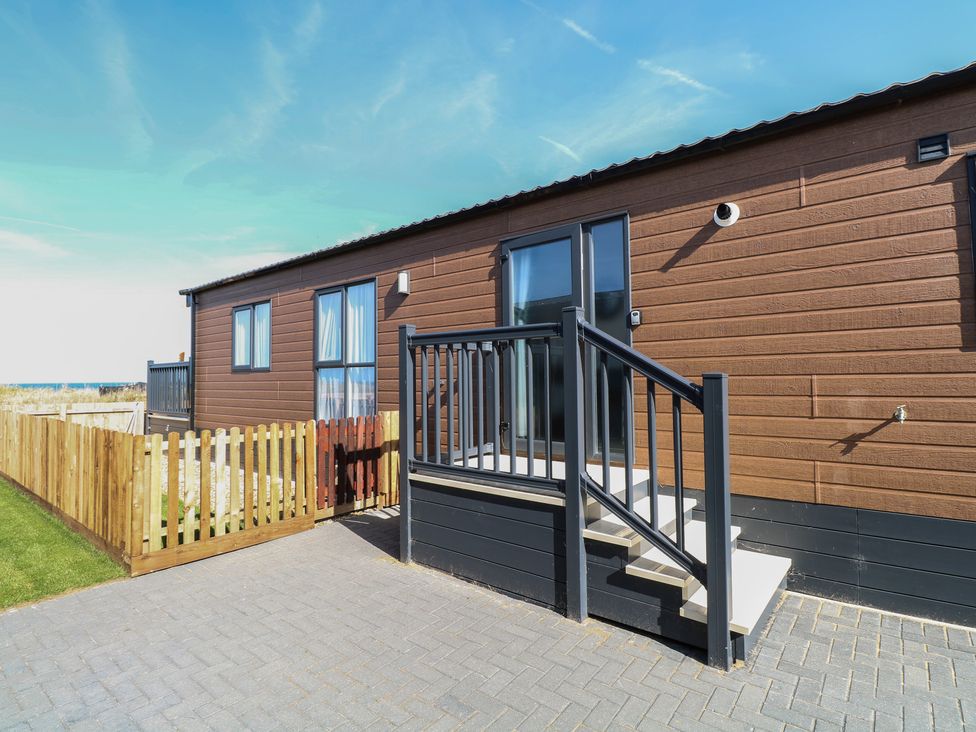 A mobile home with steps and a fence at Sand & Serenity in Bacton