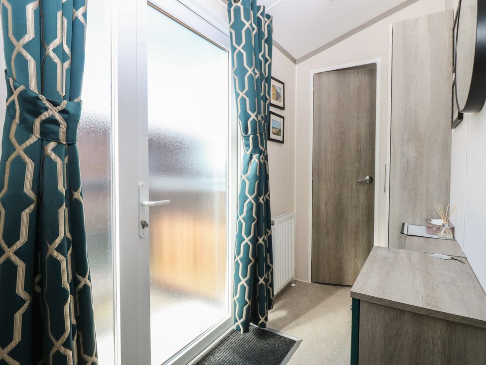 A hallway with curtains and a storage unit at Sand & Serenity in Bacton