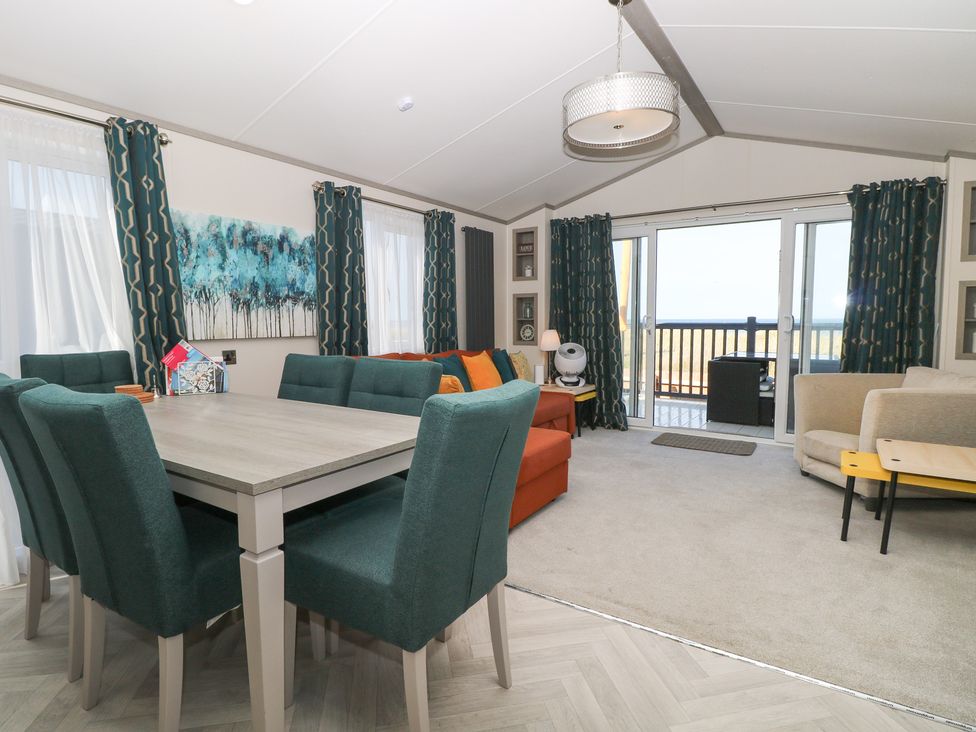 A living room with a table and chairs at Sand & Serenity in Bacton