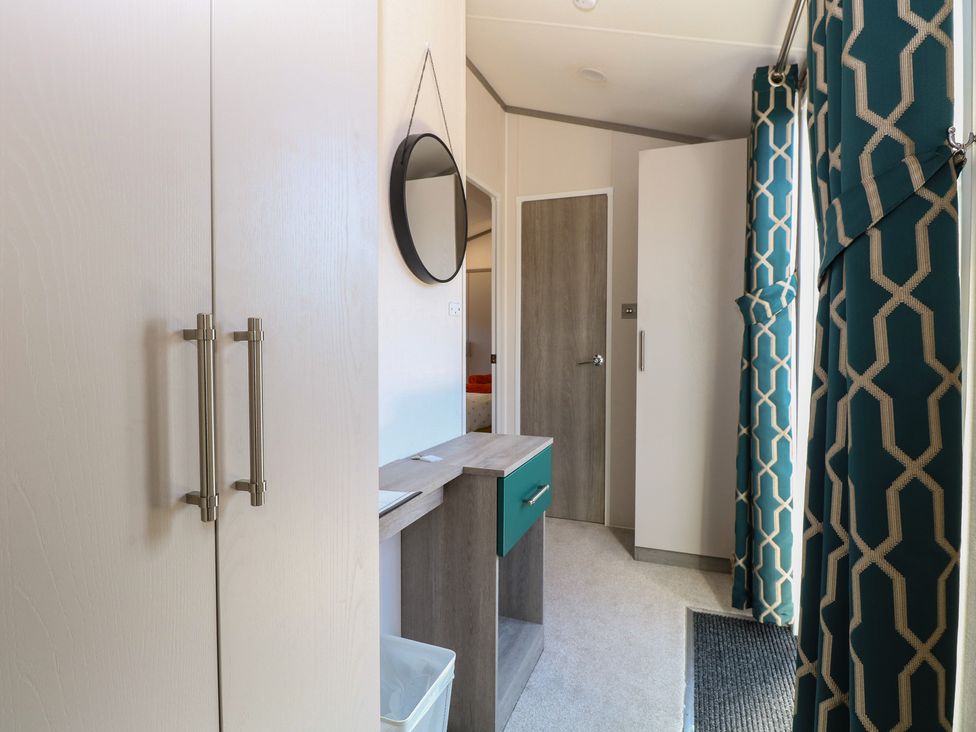 A hallway with a table and wardrobe at Sand & Serenity in Bacton