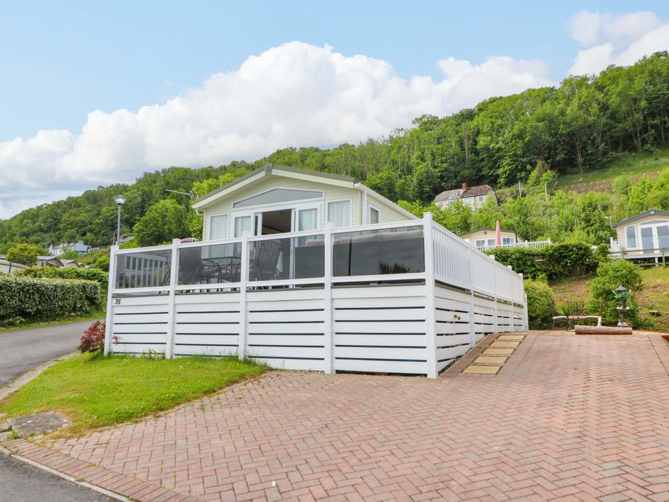 A house with a white fence and a pathway at Ty Seren in New Quay