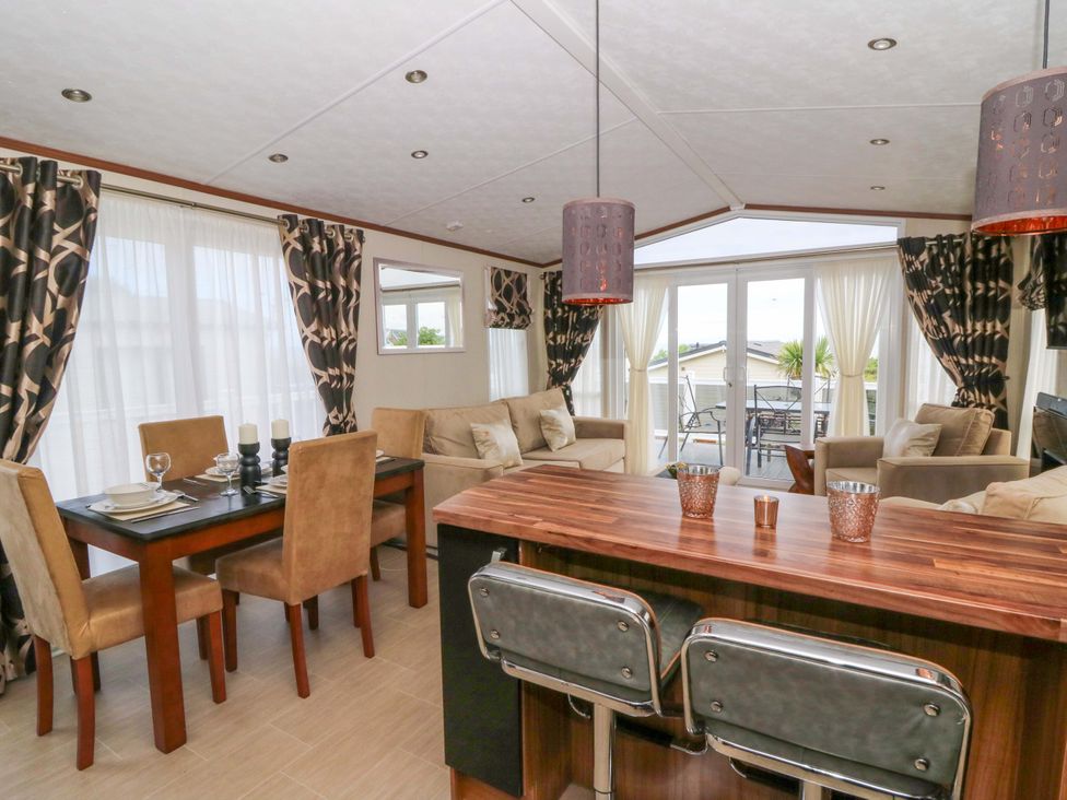 A living room with a dining area and bar counter at Ty Seren in New Quay