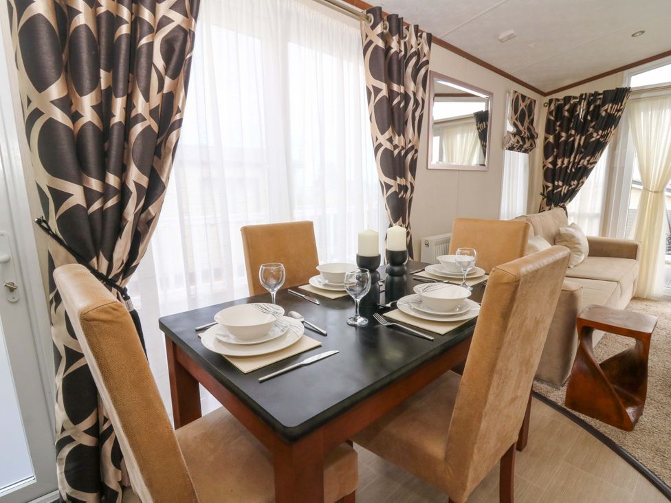 A dining room with a table set for dinner at Ty Seren in New Quay