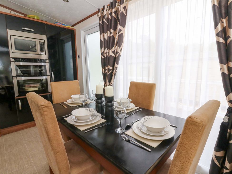 A dining room with a table set for four at Ty Seren, New Quay