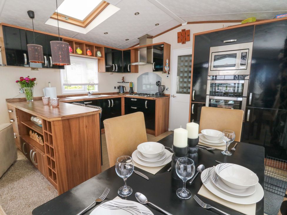 A kitchen with a dining table and stove at Ty Seren in New Quay