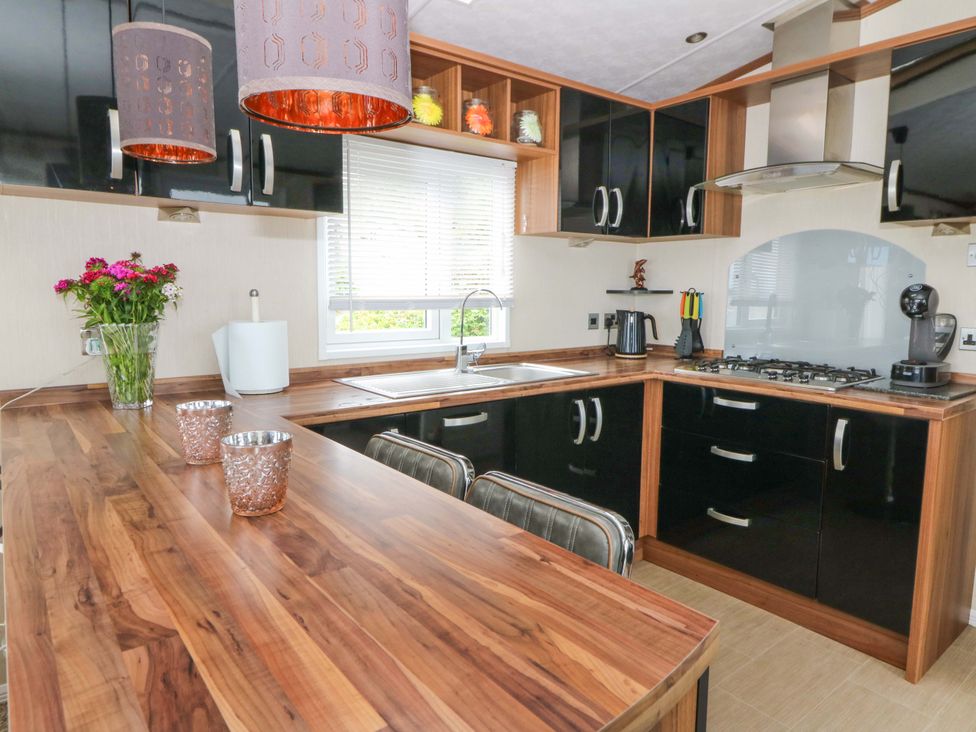 A kitchen with a sink and stove at Ty Seren in New Quay