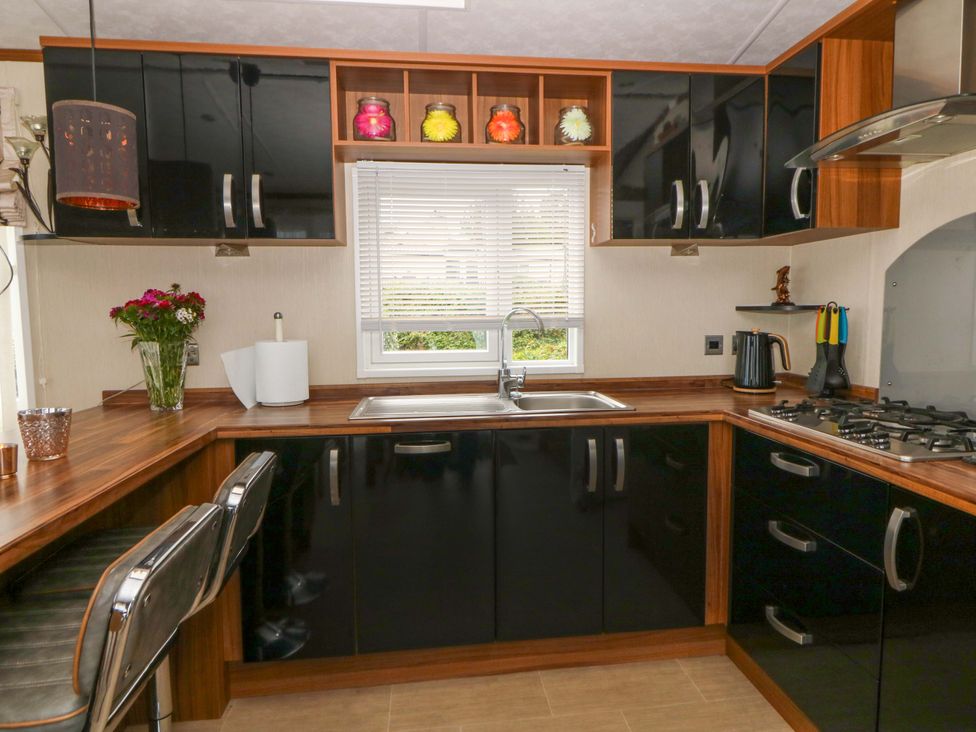 A kitchen with sink and gas stove at Ty Seren in New Quay