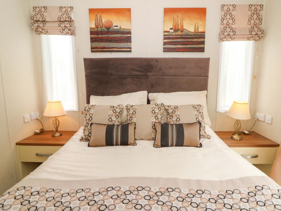 A bedroom with a bed and lamps at Ty Seren in New Quay