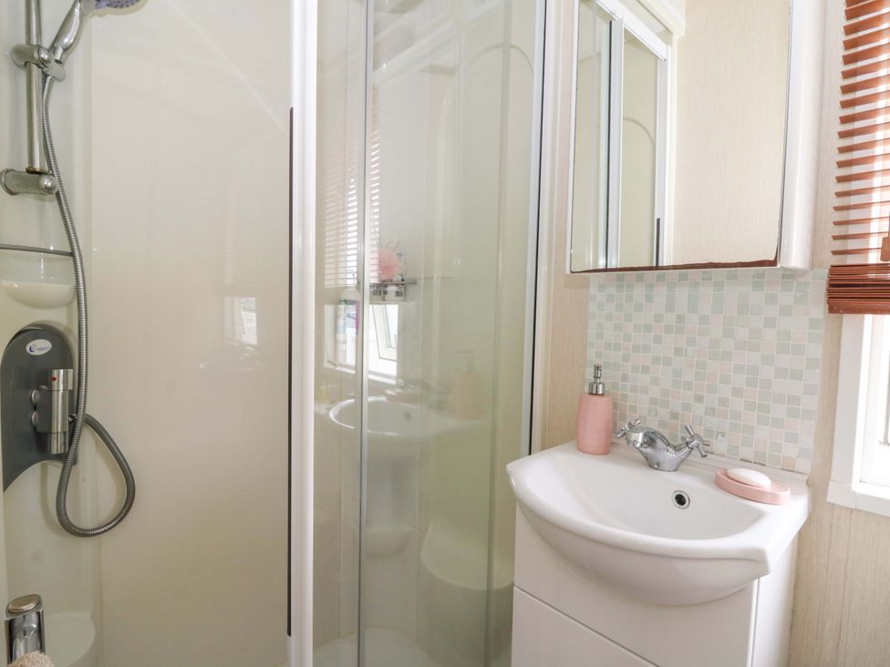 A bathroom with a shower and sink at Ty Seren New Quay