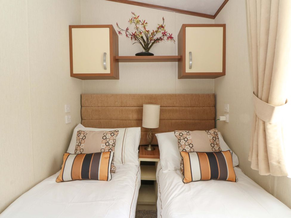 A bedroom with two beds and a lamp at Ty Seren in New Quay