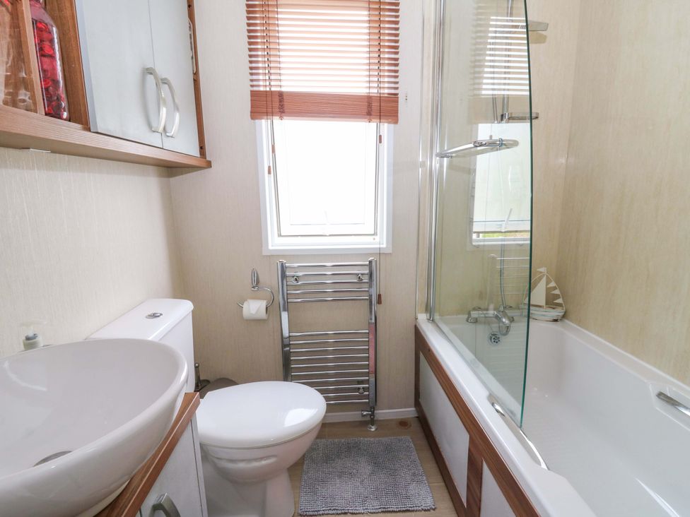 A bathroom featuring a sink, toilet, bathtub, and shower at Ty Seren in New Quay