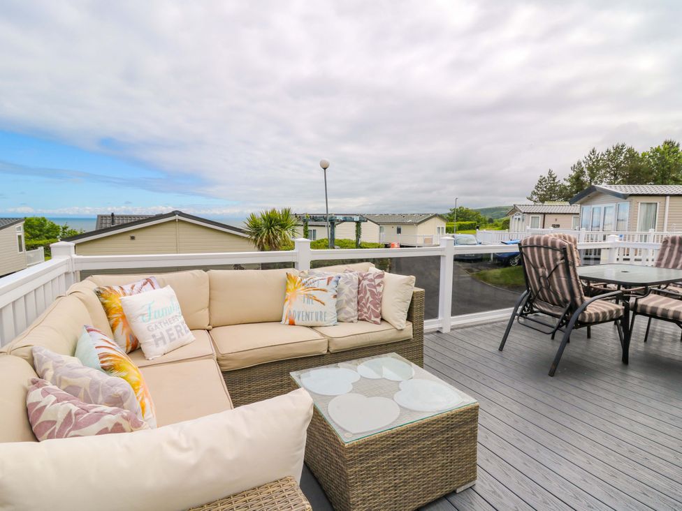 An outdoor seating area with a sofa and table at Ty Seren in New Quay
