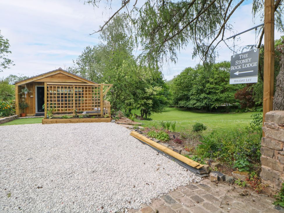 A cabin with a gravel path and lawn at Stoney Rock Lodge