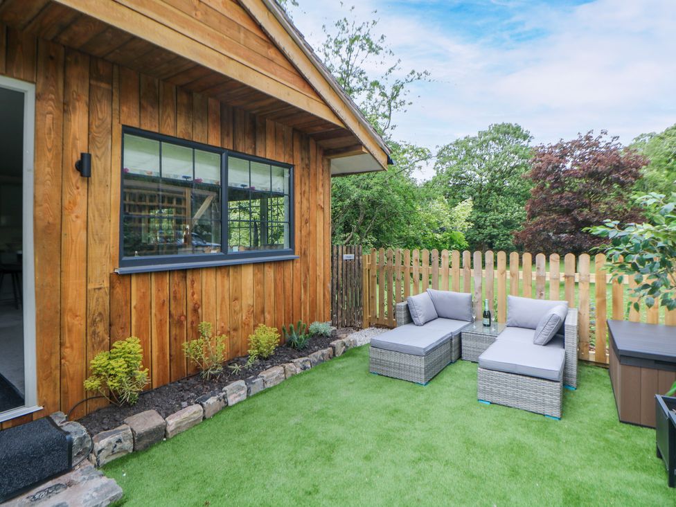 A garden with lounge chairs and a wooden wall at Stoney Rock Lodge