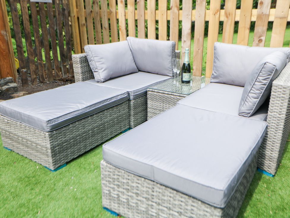 An outdoor seating area with sofa and glass table at Stoney Rock Lodge