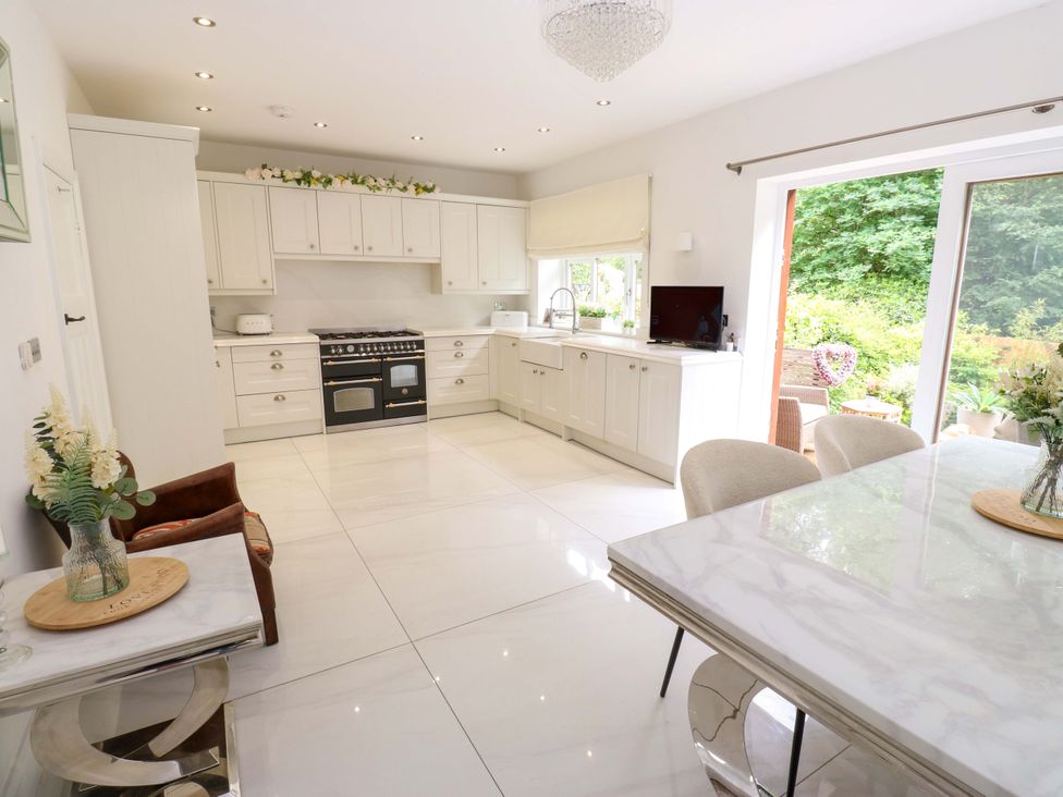 A kitchen with cabinets and a table at St Mary's House Oldham