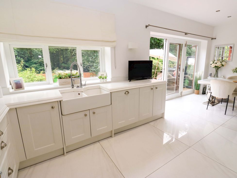 A kitchen with a sink and television at St Mary's House in Oldham