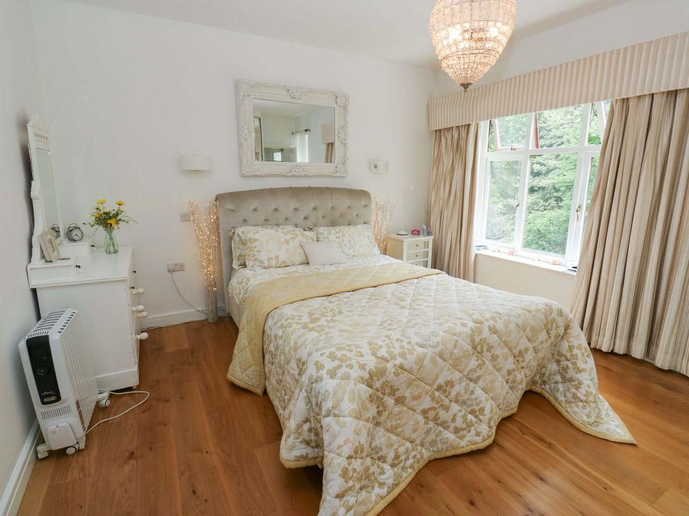 A bedroom with a bed and chandelier at St Mary's House in Oldham