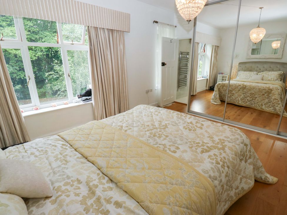 A bedroom with a bed and large windows at St Mary's House in Oldham