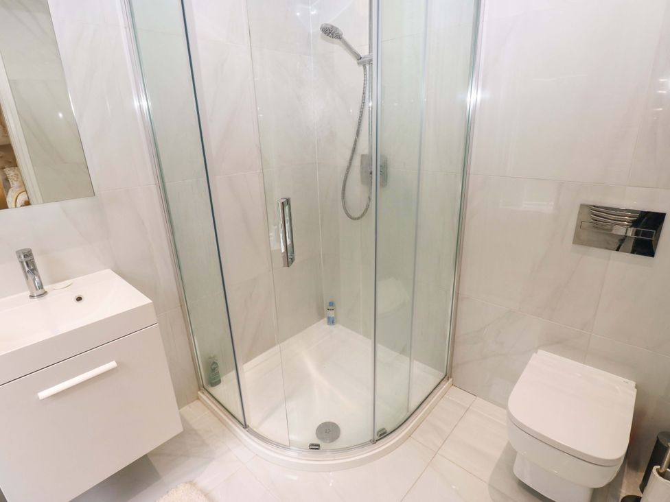 A bathroom with a shower, toilet, and vanity at St Mary's House in Oldham
