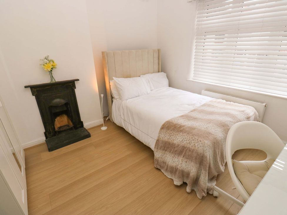 A bedroom with a bed and chair at St Mary's House in Oldham