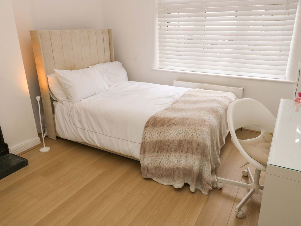 A bedroom with a bed and desk at St Mary's House in Oldham