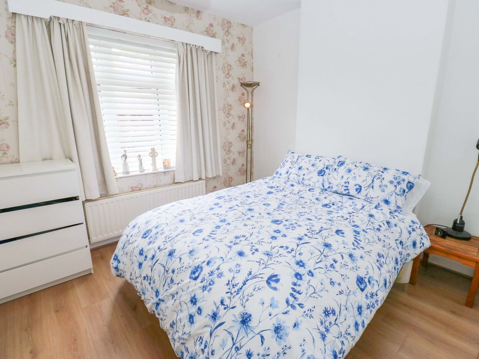 A bedroom with a bed and dresser at St Mary's House in Oldham