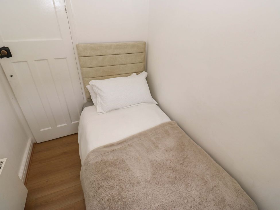 A bedroom with a single bed and a door at St Mary's House in Oldham