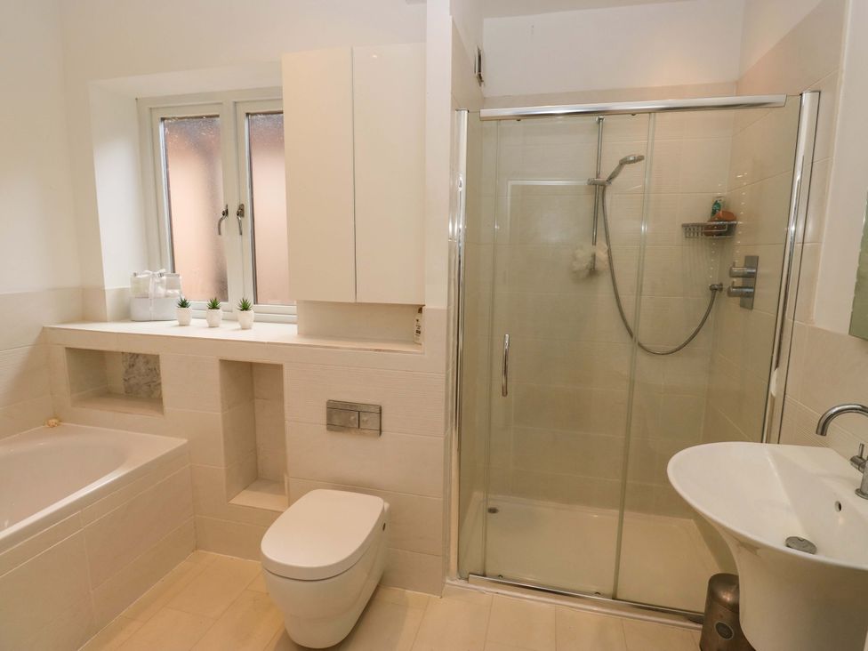 A bathroom with a bathtub, shower, toilet, and sink at St Mary's House in Oldham