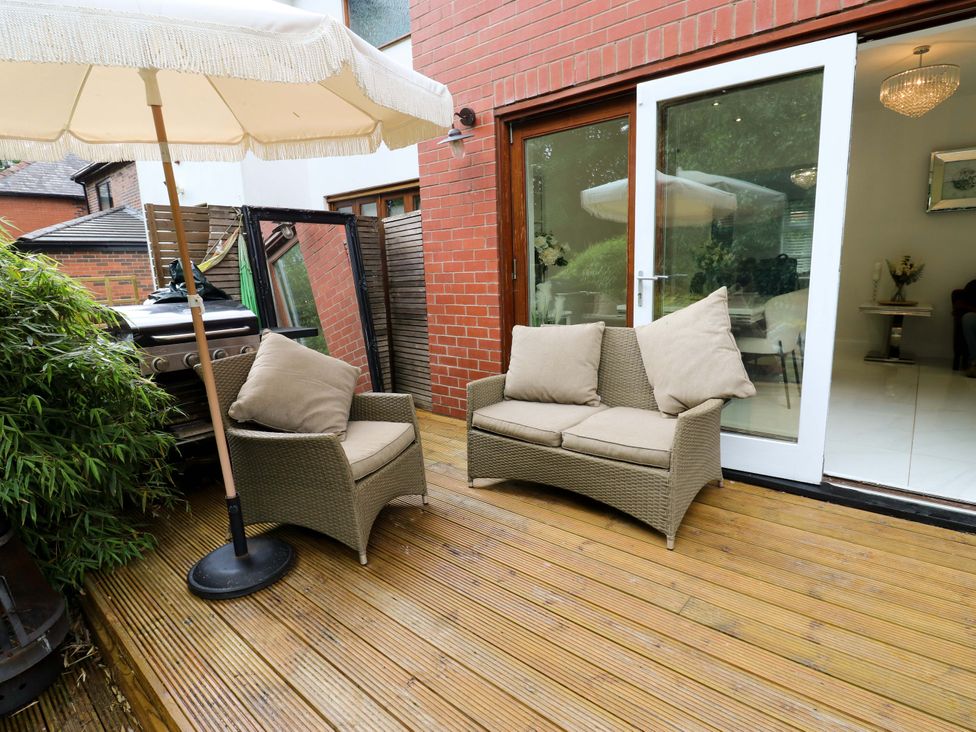 A seating area with sofa and umbrella at St Mary's House in Oldham