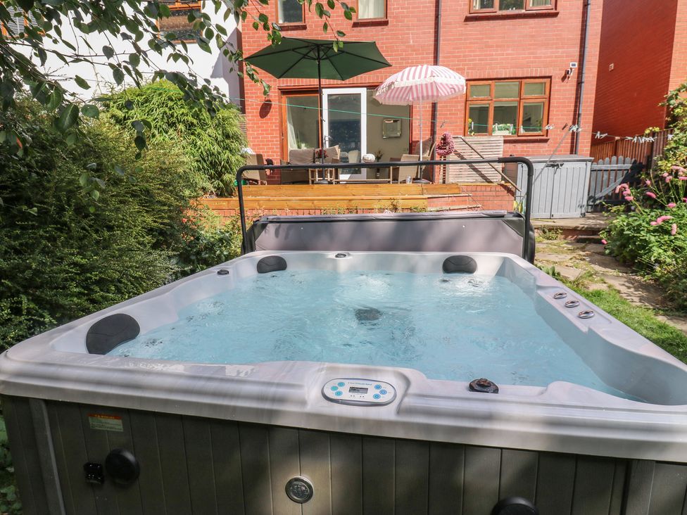 A hot tub and seating area in a garden at St Mary's House Greenfield