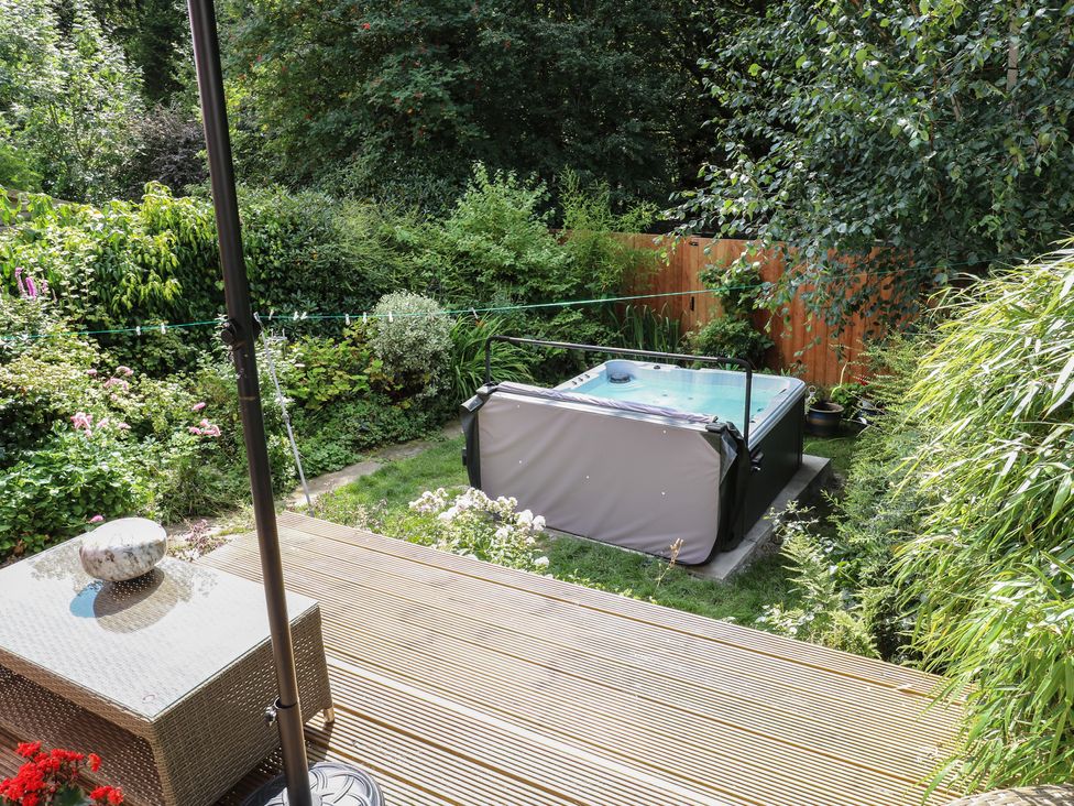 A garden with a hot tub and outdoor furniture at St Mary's House in Greenfield