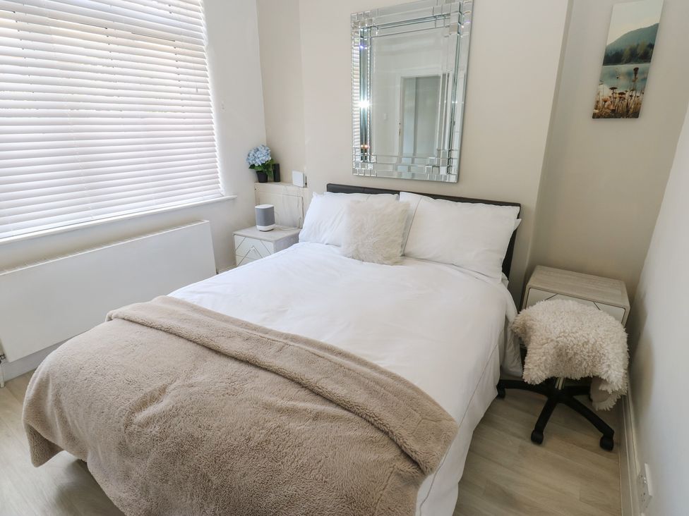 A bedroom with a bed and mirror at St Mary's House in Greenfield