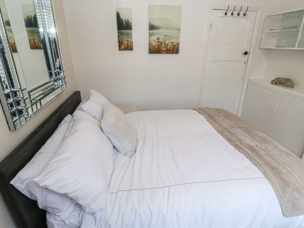 A bedroom featuring a bed with white bedding and wall art at St Mary's House in Greenfield