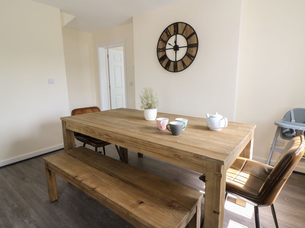 A dining room with a wooden table and chairs at Glandwr House Llandrindod Wells