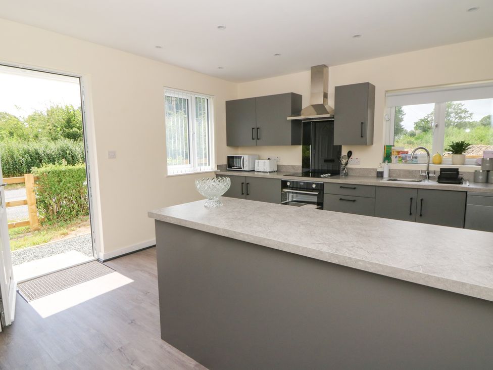 A kitchen with a countertop, stove, and sink at Glandwr House in Llandrindod Wells
