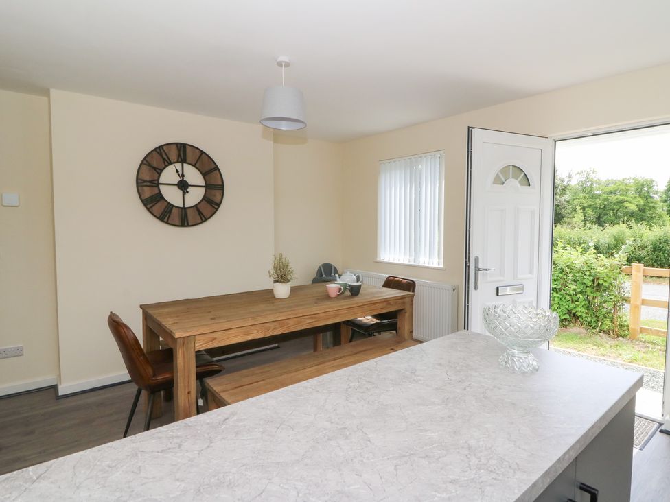A dining room with a wooden table and chairs at Glandwr House in Llandrindod Wells